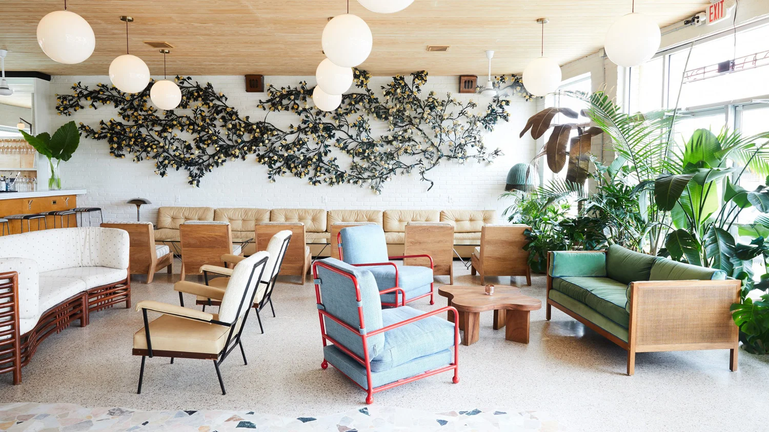 The Drifter hotel lobby, in New Orleans, invites guests with the gentle curvature of plenty styles of hip furniture. 