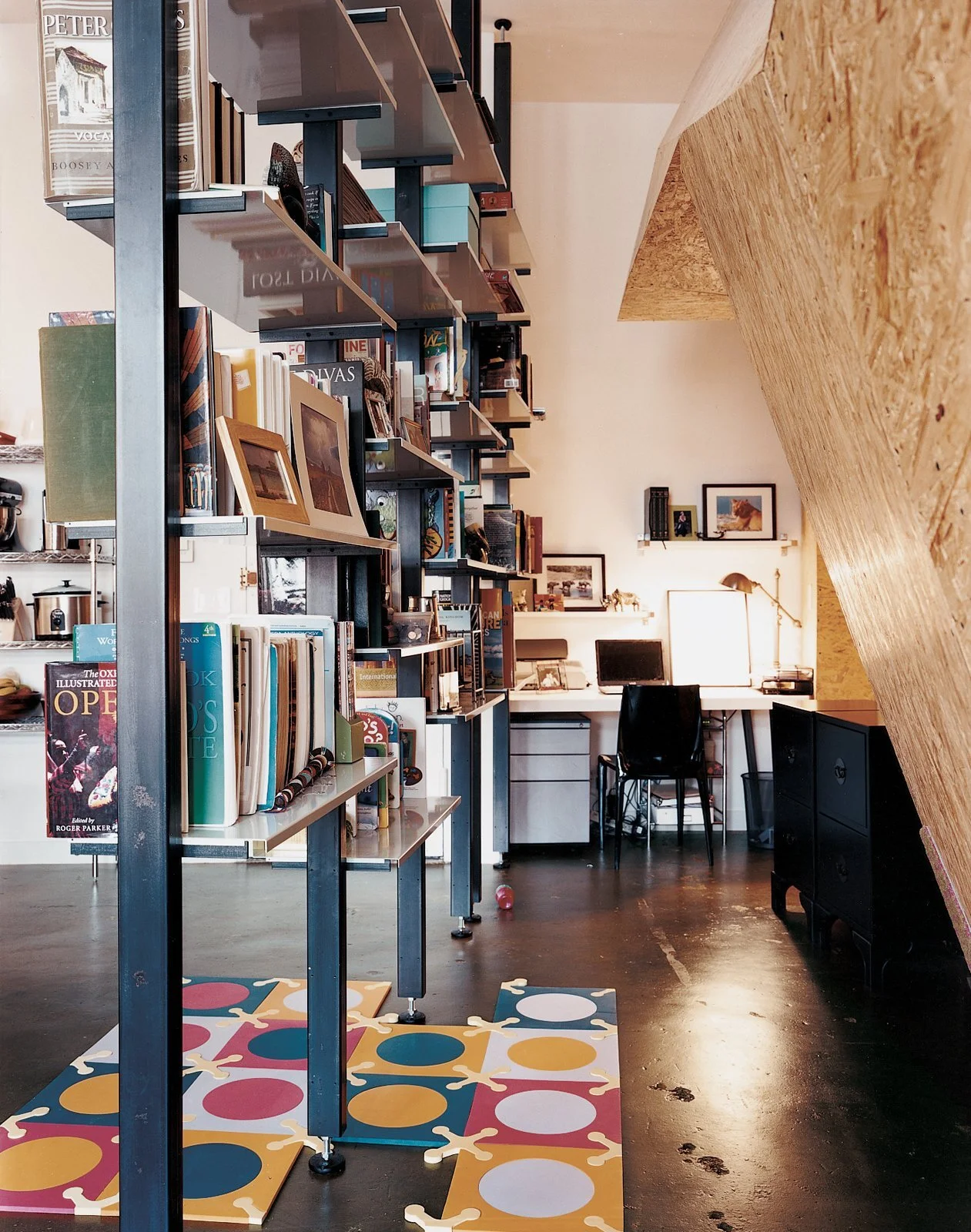 custom-fabricated-modular-bookshelves-create-a-corridor-leading-to-the-home-office.jpg