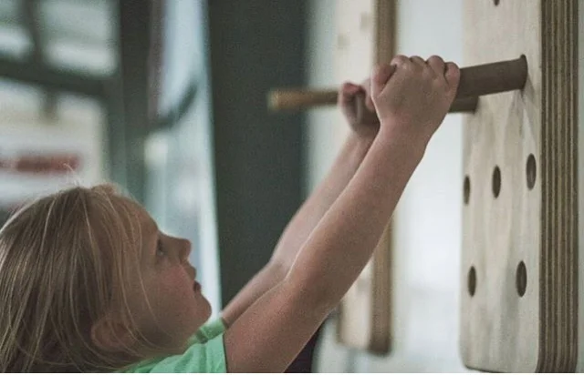 Kaydence testing the peg-board during CrossFit Kids