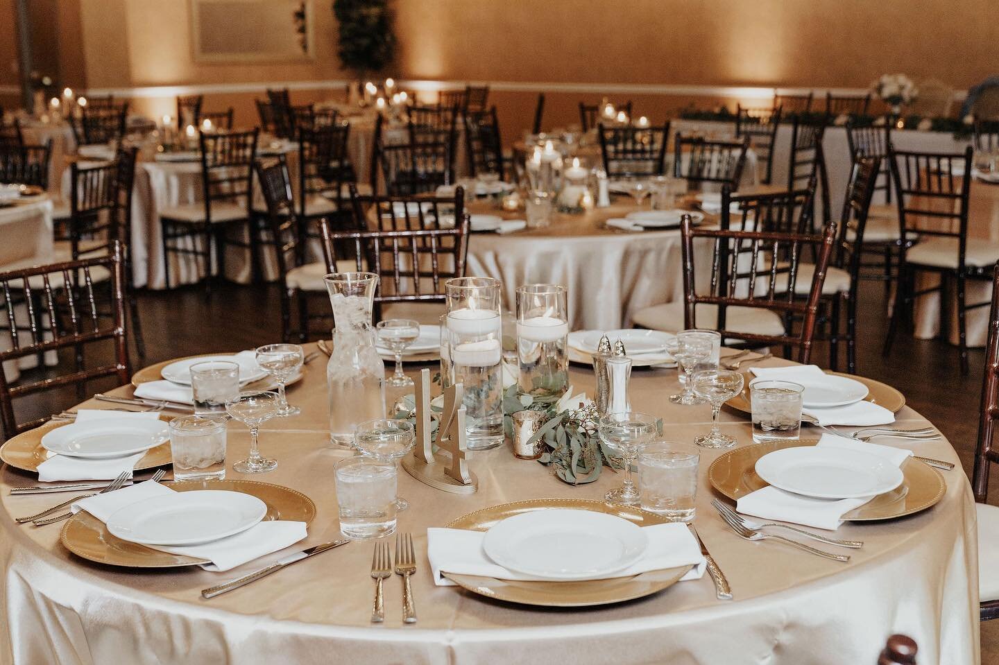 ⚜️ Gold works so well in our ballroom 
Note the complimentary gold charger plates, glass pillar vases, and up lighting in the background - all included in your package among other amenities ✨

Photo: @marisaclaire.photo 
#goldwedding #champagnelinens