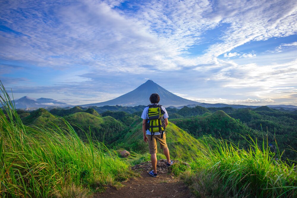 man-wearing-white-shirt-brown-shorts-and-green-backpack-672358.jpg