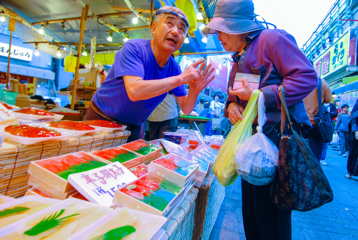  In the Ameyoko market next to Ueno Station, a gray haired man does his best to convince a woman that the price he is asking for salmon roe is really the best he can do, she does not look convinced&nbsp; 