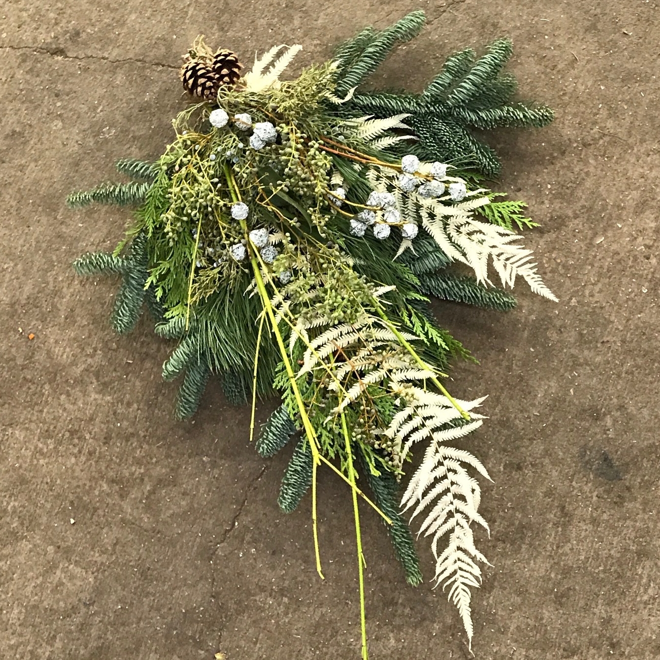Bleached fern fronds add unique texture to this door swag made by the staff at Welch.