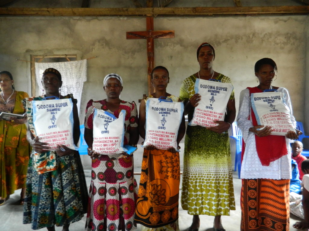 Group of locals holding the maize funded by St. Bryce Missions