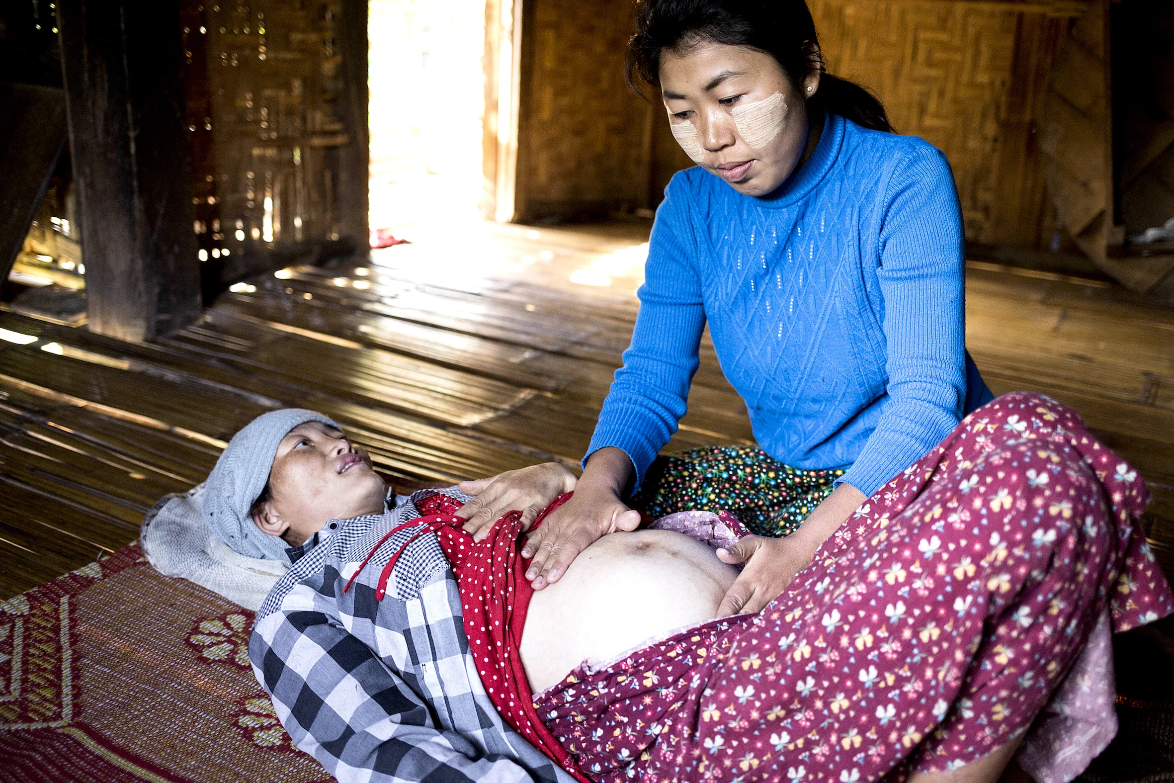 Burmese midwife assisting during a labor and delivery.