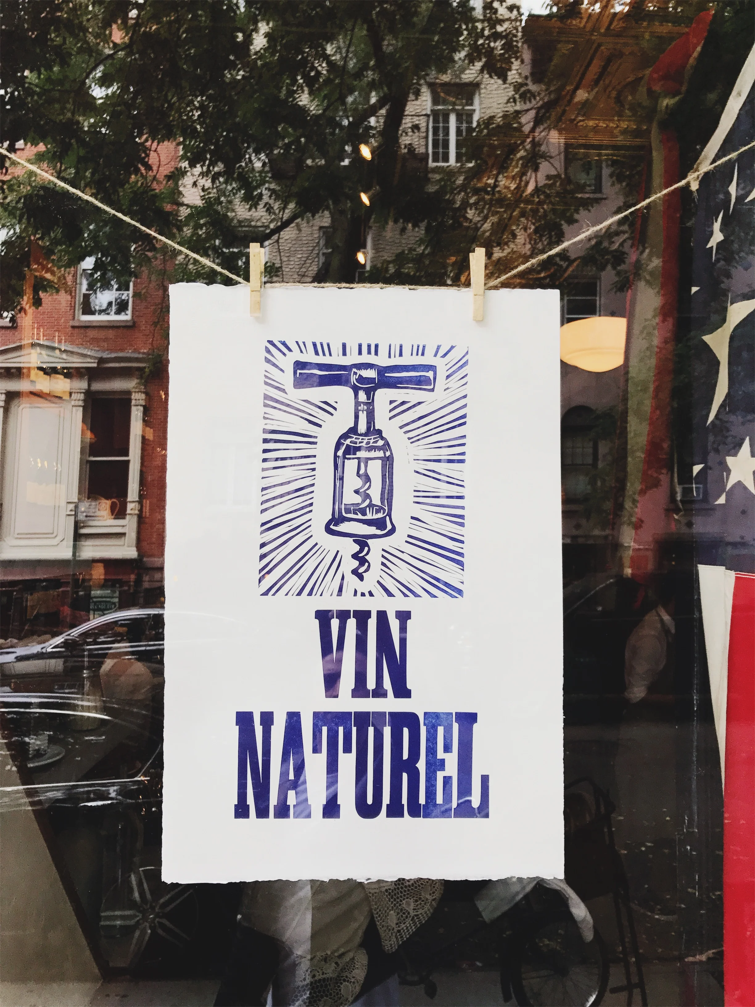 Vin Naturel poster hanging in a window