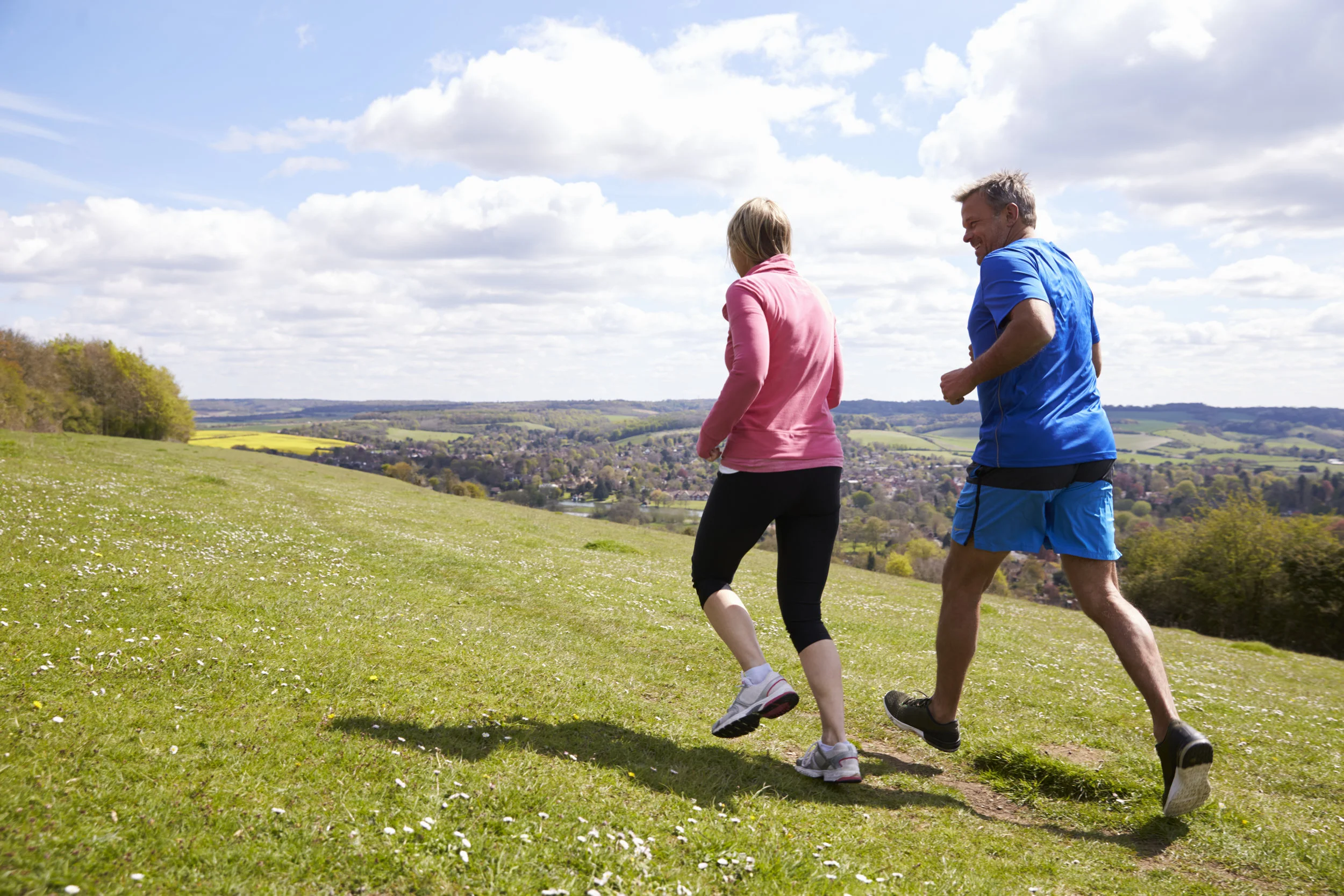 rear-view-of-mature-couple-jogging-in-countryside-PCZPHQK.jpg