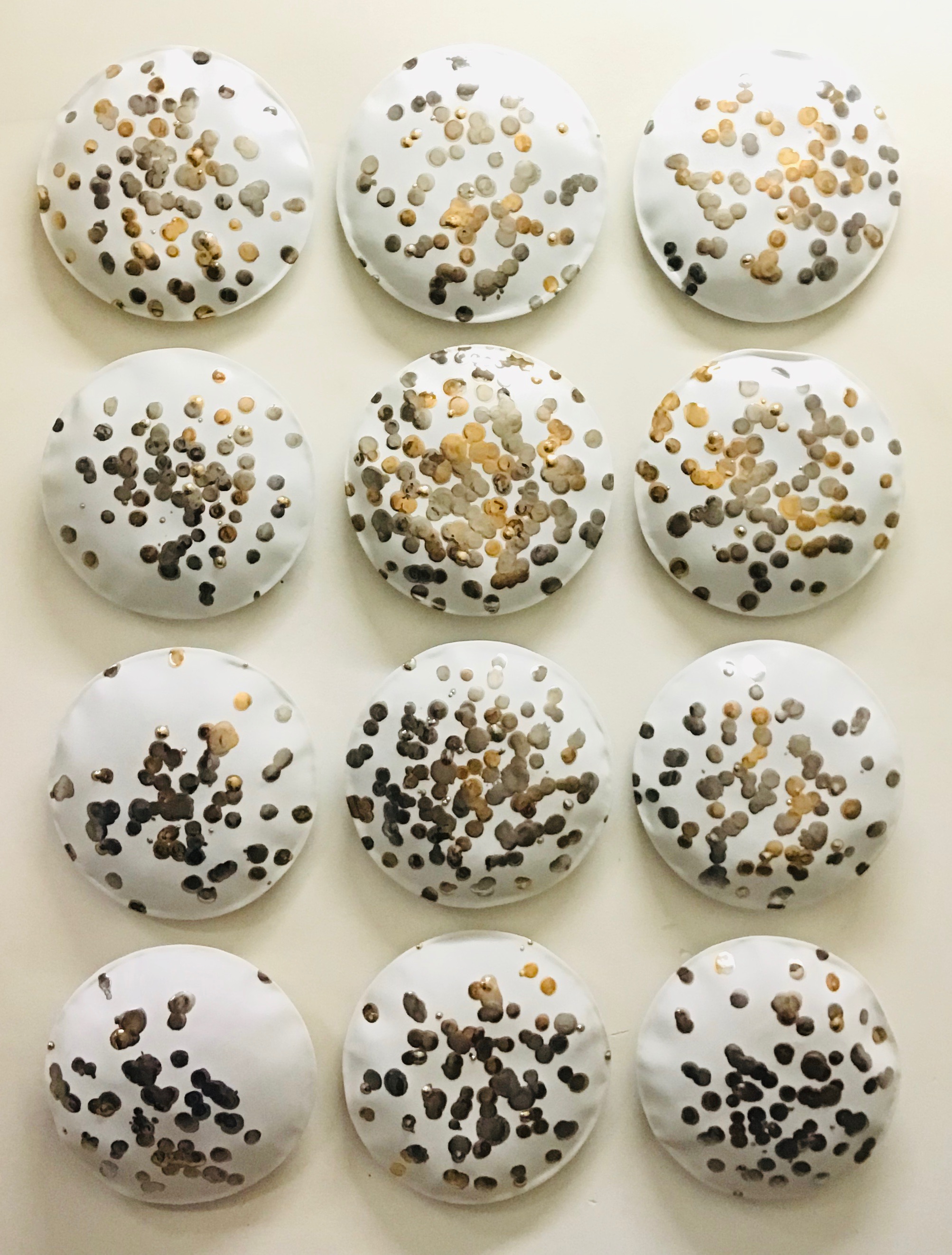  12 handmade porcelaine pillows, 24K gold and silver glaze.  Each pillow is 9.5 in. diameter. Total installation size: H 43 x W 32 in.  Vertical and horizontal installation. Sold individually.    