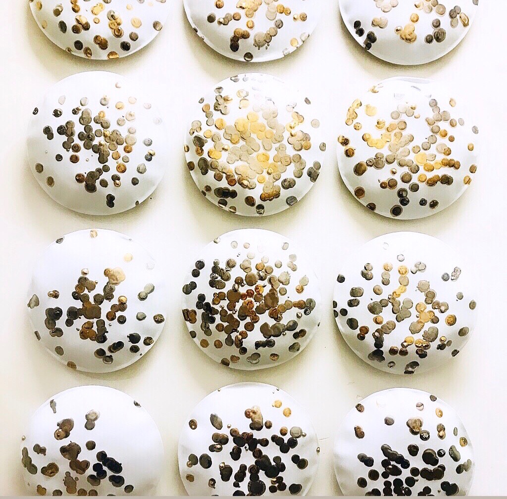  12 handmade porcelaine pillows, 24K gold and silver glaze.  Each pillow is 9.5 in. diameter. Total installation size: H 43 x W 32 in.  Vertical and horizontal installation. Sold individually. 