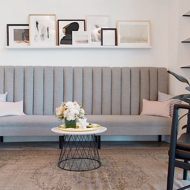A peek at the reception area of our @theblinkbar Calabasas project. We did an extra tall channel tufted banquette to draw the eye up as the ceilings are sky-high. A muted palette, layered artwork, potted rubber tree,  and vintage rug give off residen