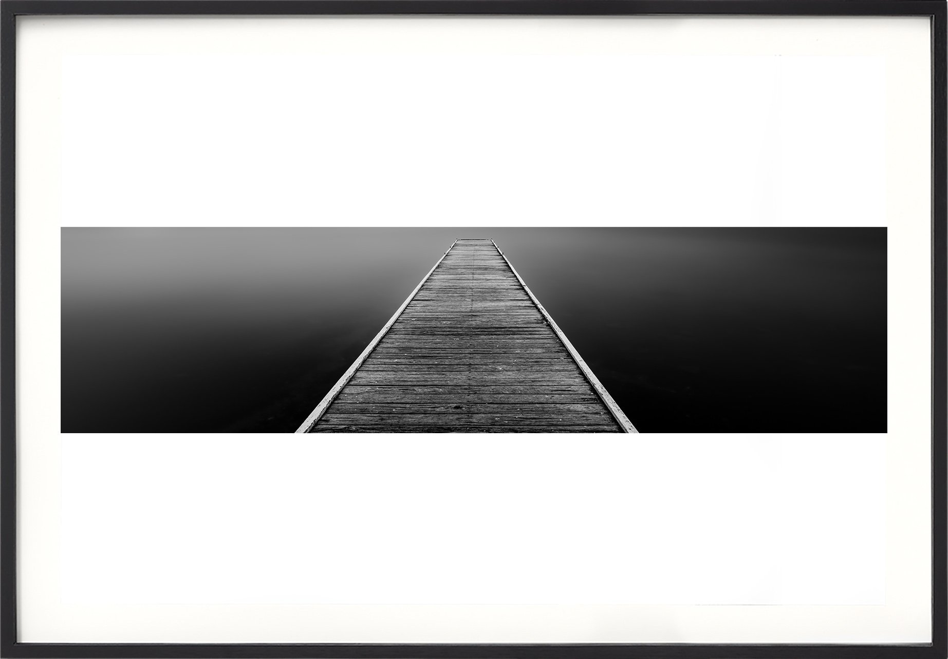 Black and white panorama of a wooden jetty above water smoothed by a 4 minute exposure