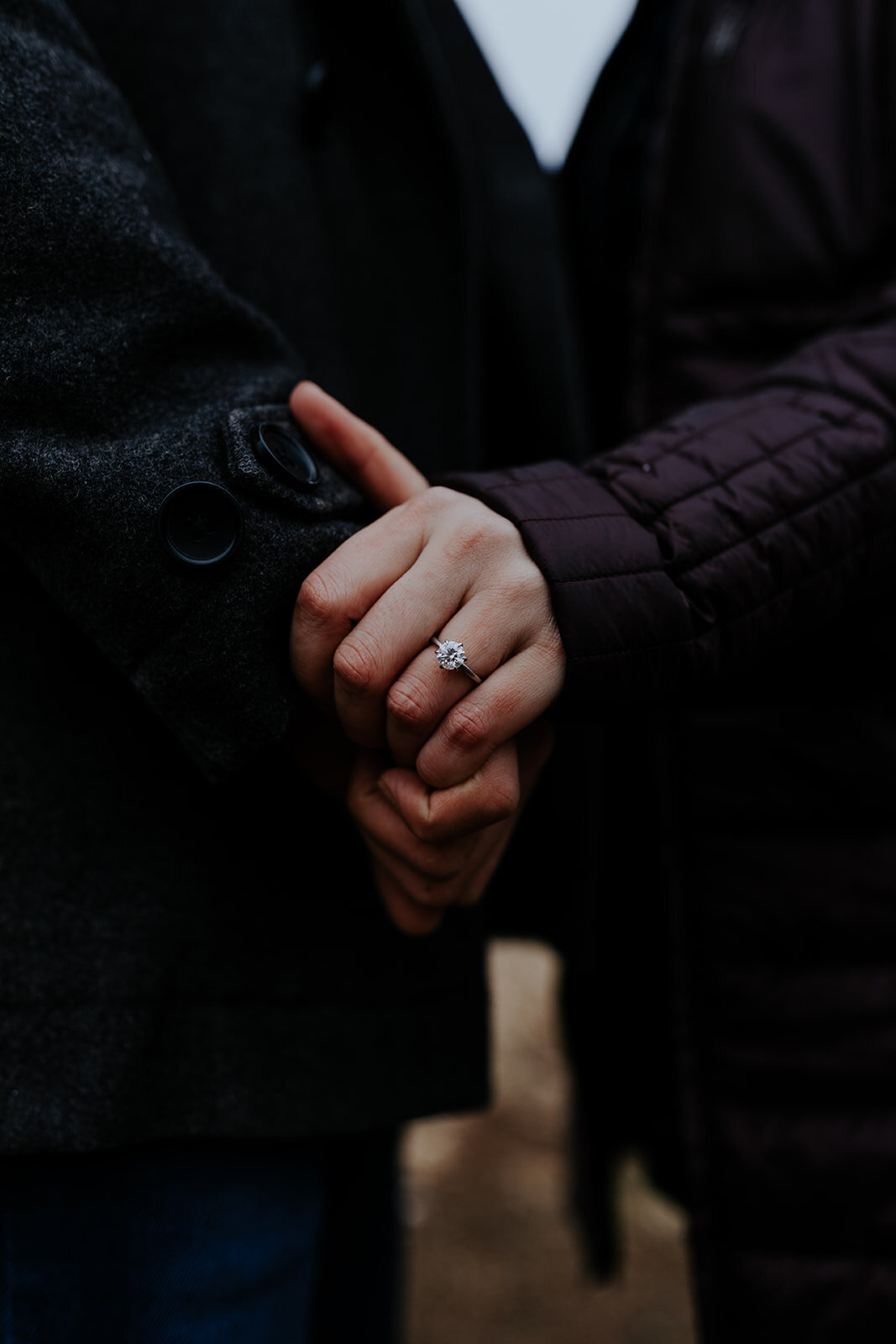  close up of a couple’s hands with engagement ring 