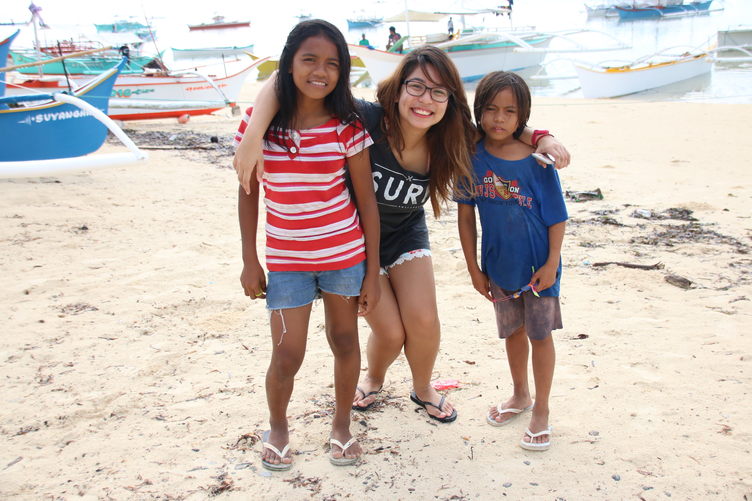 The Millennial Mermaid hanging around with local kids from the neighbouring municipality on the shores of General Luna’s bustling Boulevard. Photo by Alex Lopez. Shirt: Reefside Artworks