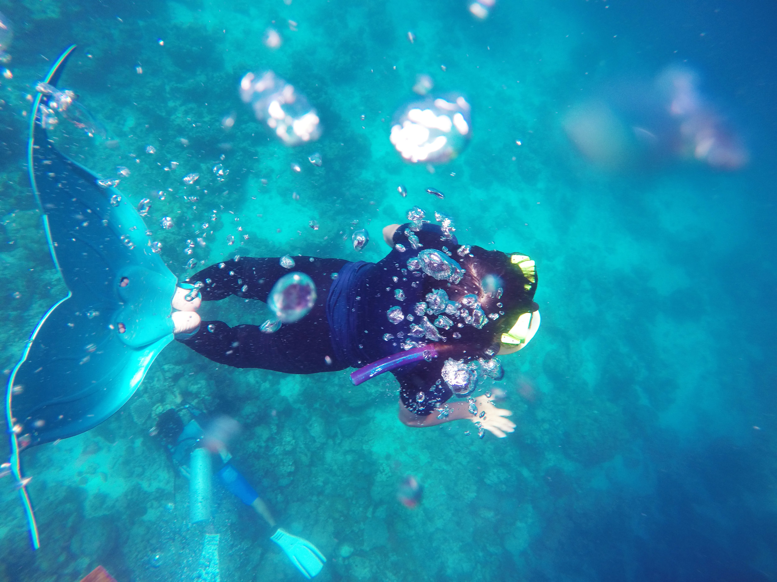 Channeling her inner mermaid, Dayanara Tan, goes for underwater cartwheels as she tries on my mermaid fins. Photo by Bianne Yee.