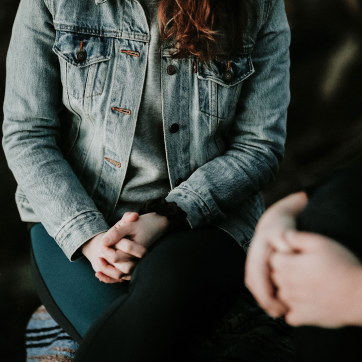 Two people praying together with their hands closed.