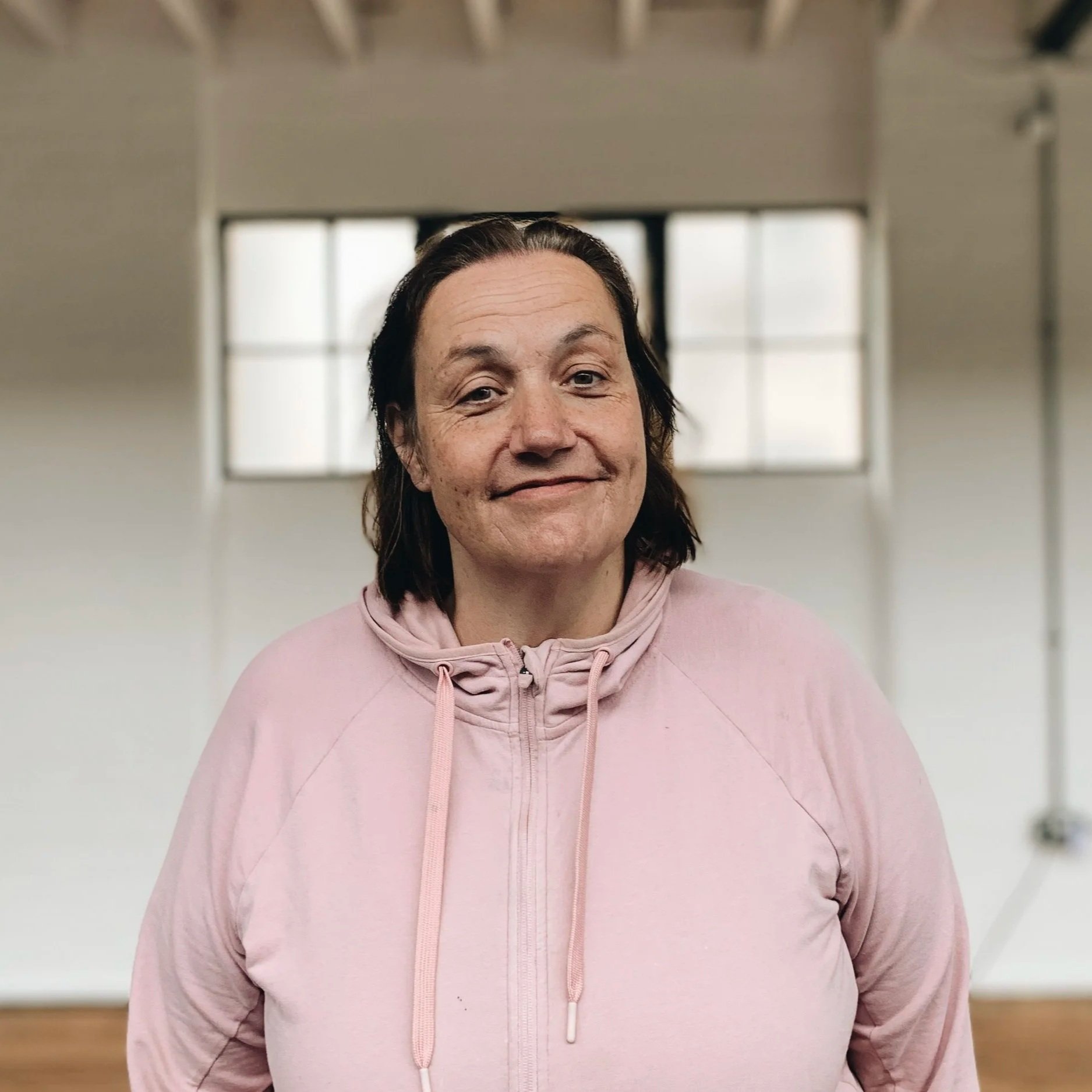 A smiling Jane Overnell standing in front of a wall.