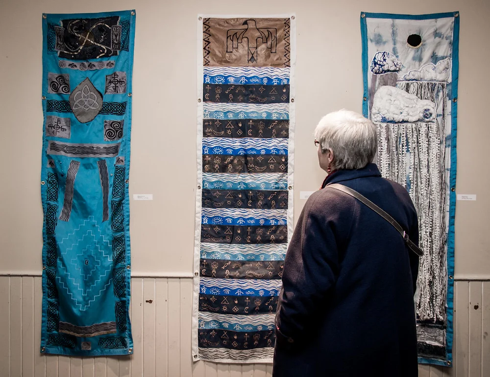 A Water Docs patron engages with several pieces from Water Advisory! , on display at the 2018 Water Docs Film Festival.