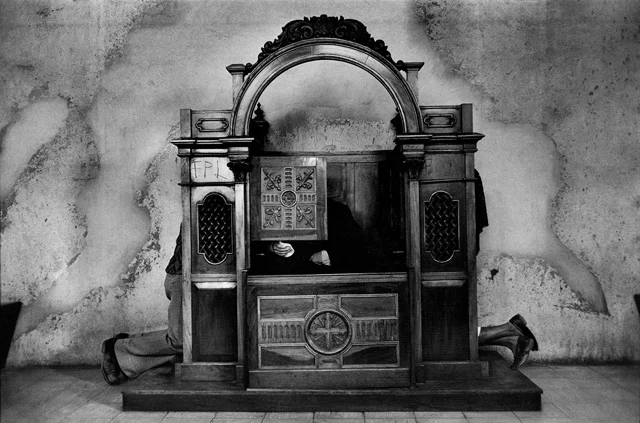 EL SALVADOR, 1982: A priest hears confessions in the cathedral.