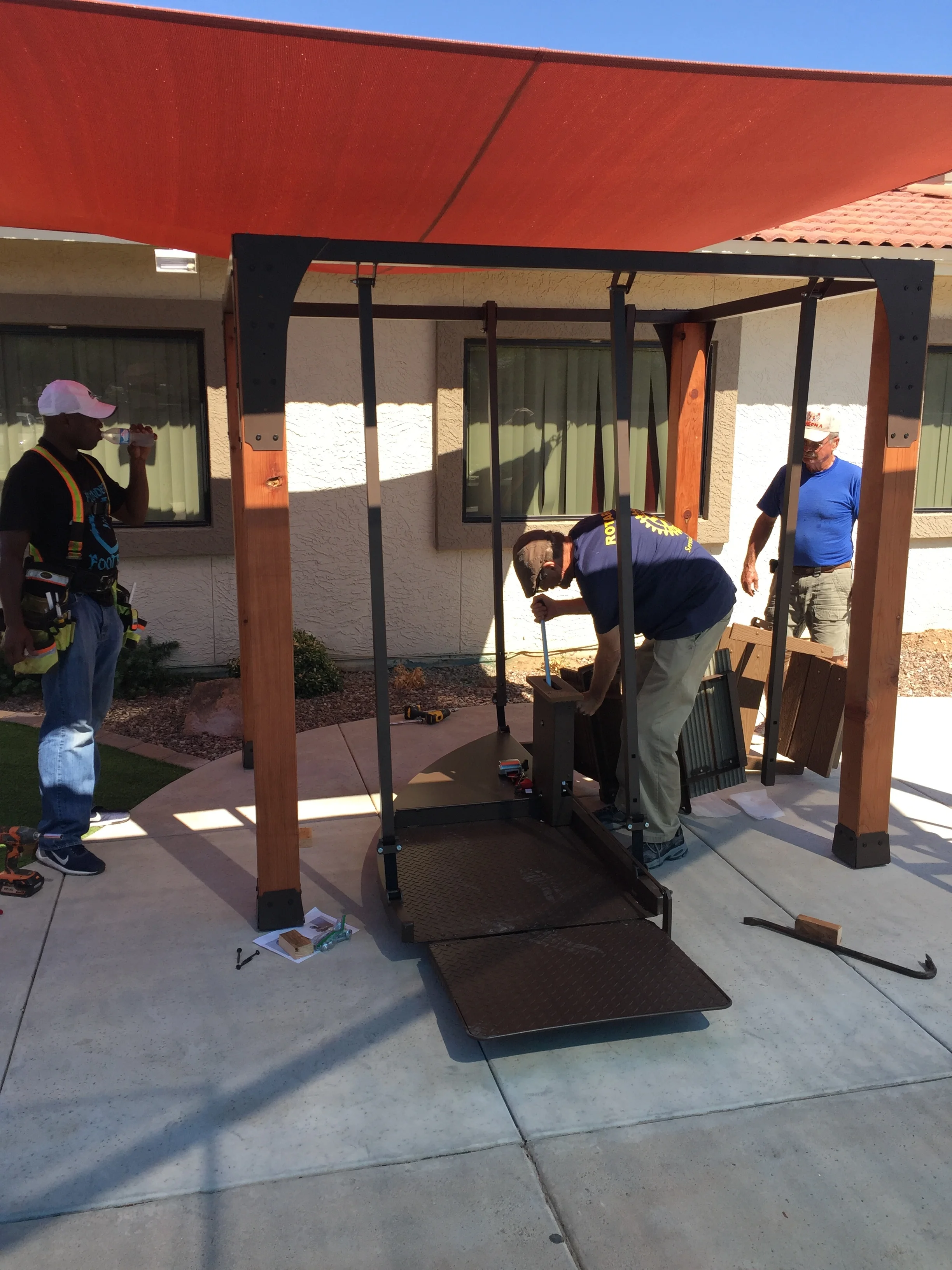 Rotary members Plas and Lee assembling the wheelchair swing.