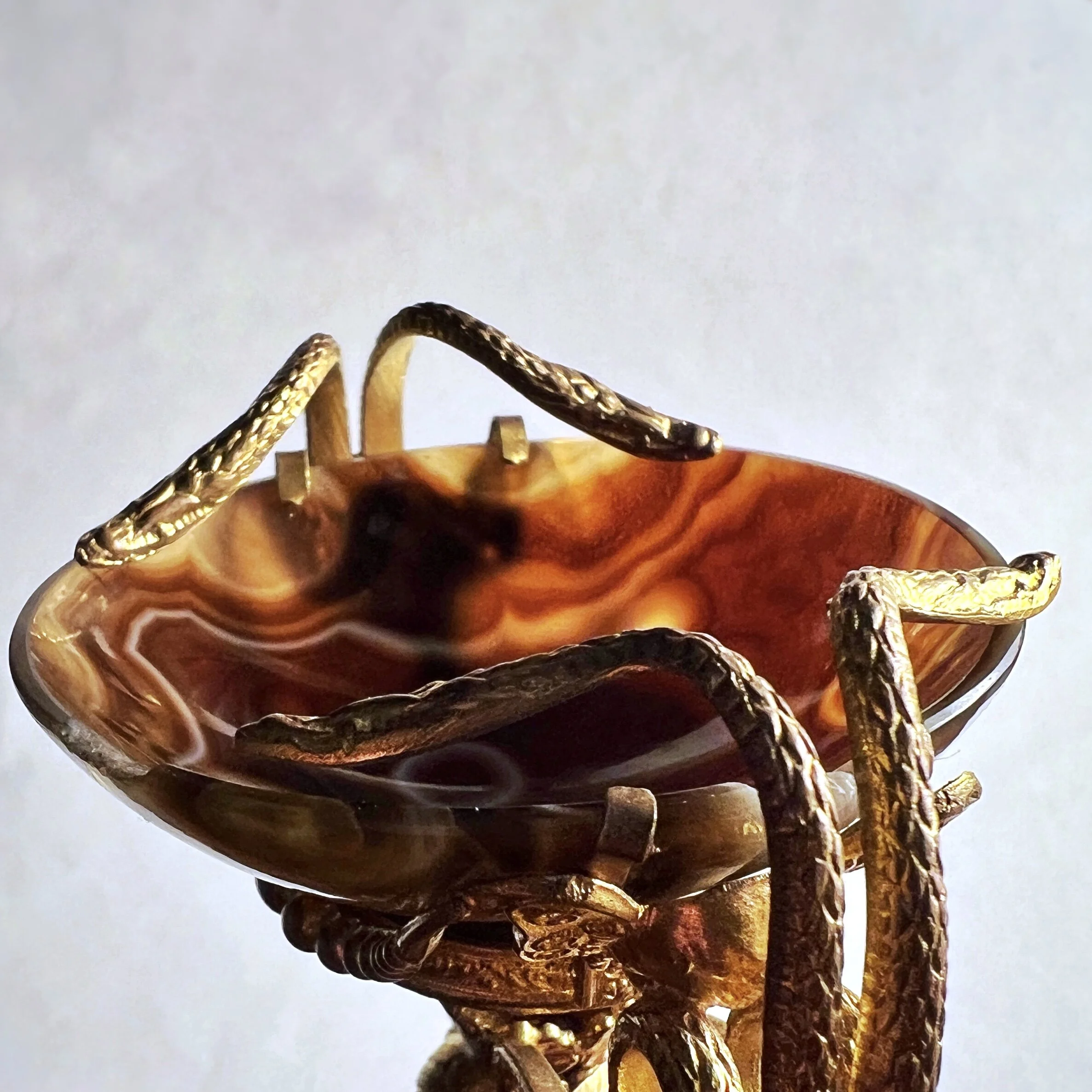 Snakes encircle a hardstone cup