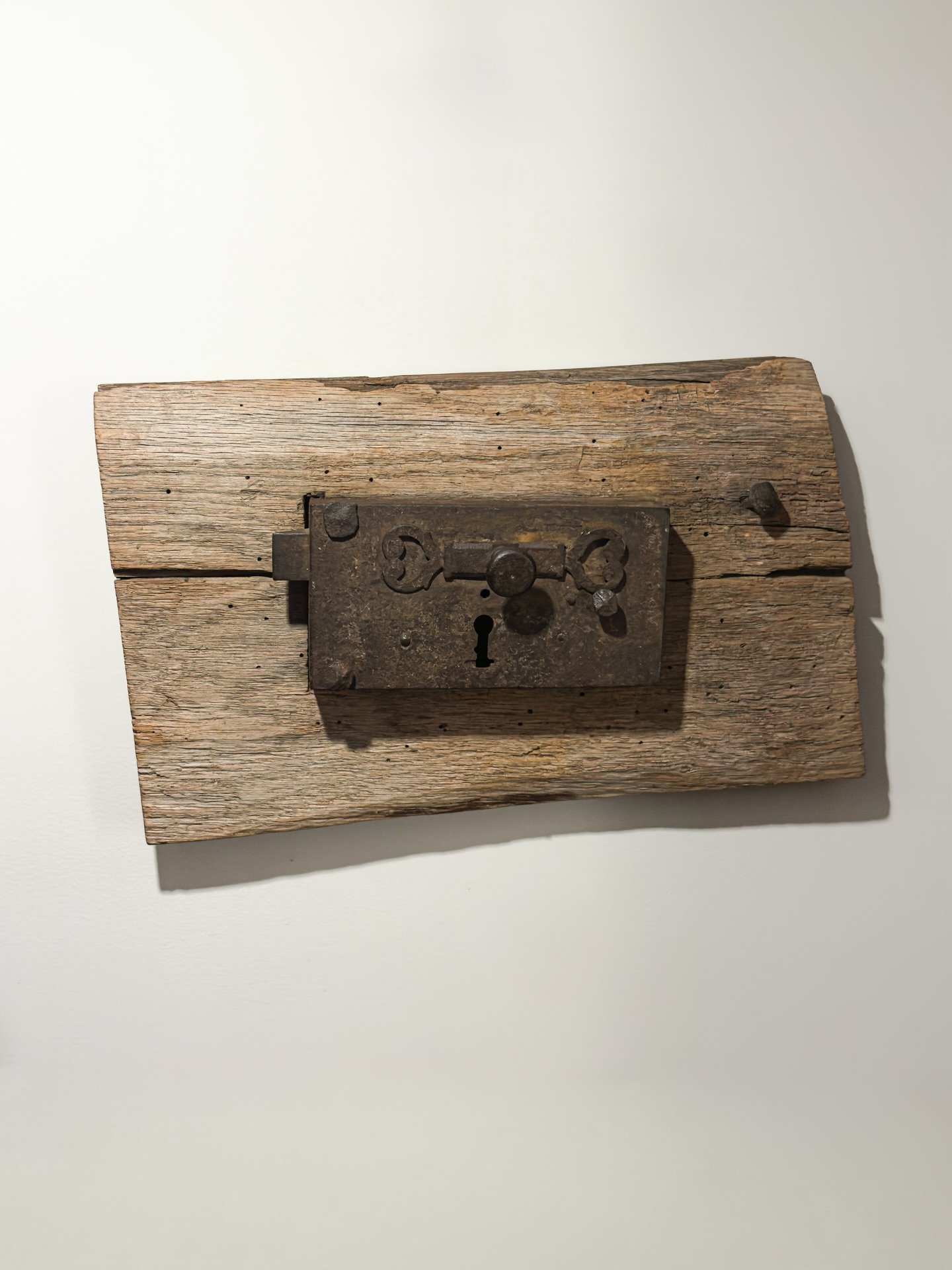 Available. DM. Wrought Iron Rim Lock with spring bolt and horizontal slide bar, probably English (Birmingham or Midlands), in colonial New England use. Late 17th&ndash;early 18th c. Mounted on a period piece of timber, the lock and associated timber 