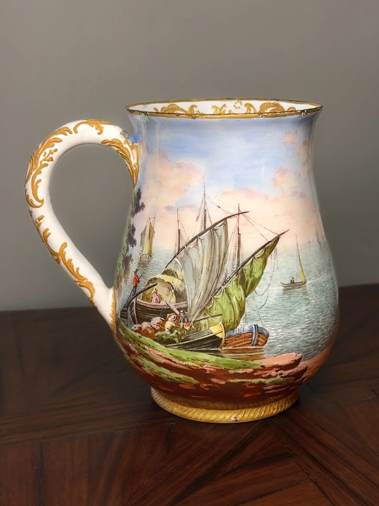 Available. DM. 18th-century South Staffordshire (Bilston) enamel cann, enamel on copper, hand-painted with continuous nautical harbor scenes - fishermen hauling nets, ships at anchor, and a distant town under a rose-blue sky. A rare full-size cann fo