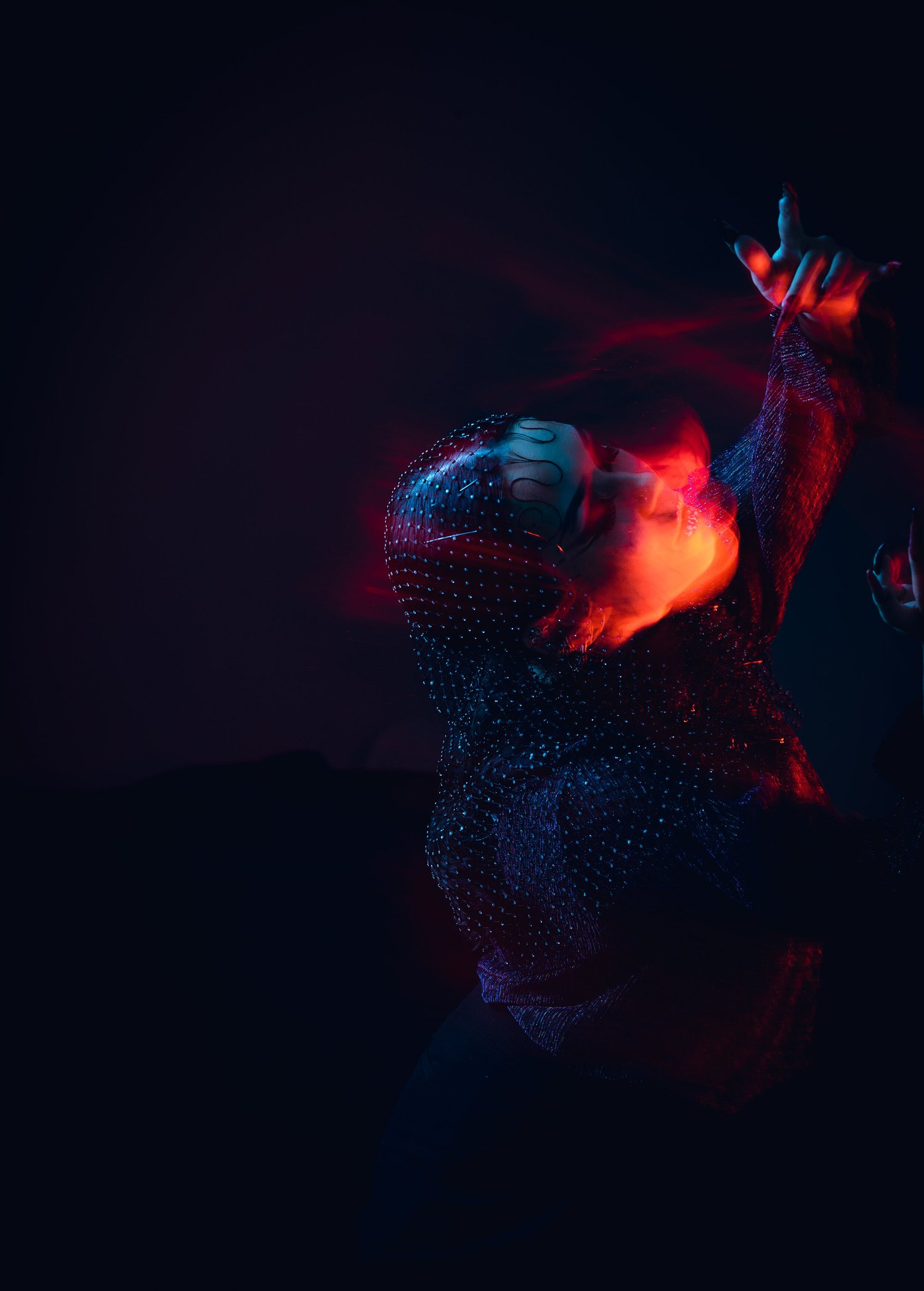 Marty Crown reaching toward the camera in red and dark blue light