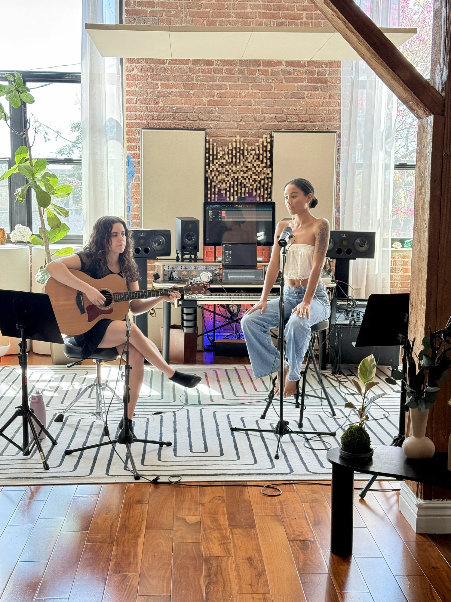 Two musicians with a microphone and guitar during a studio session