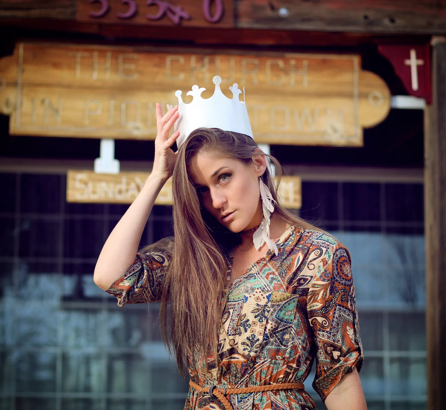 Moana Avvenenti wearing a patterned dress and paper crown in Pioneertown