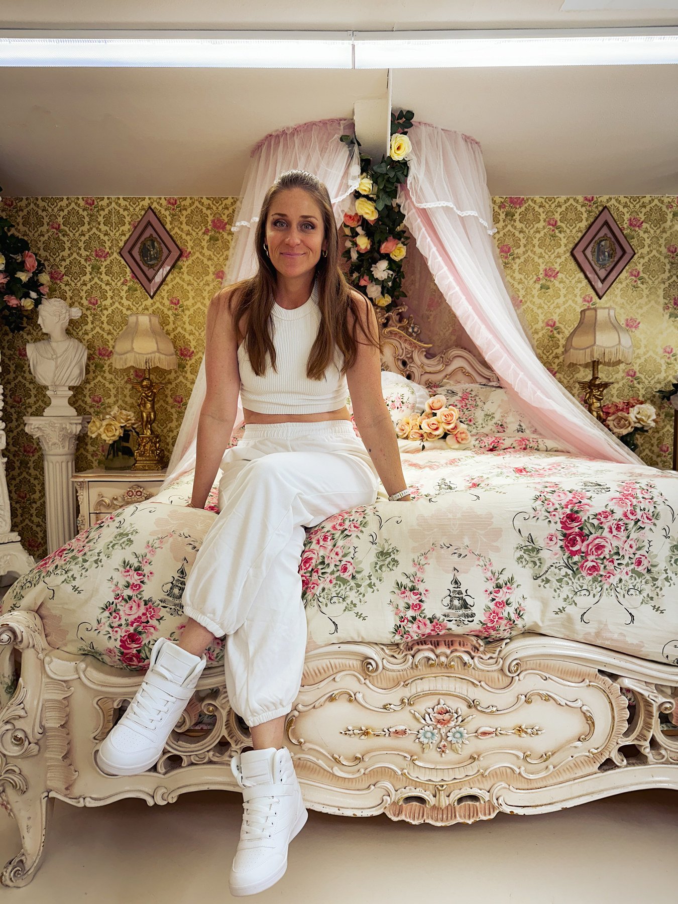 Moana Avvenenti dressed in ivory, seated in a room with floral fabrics and gold details