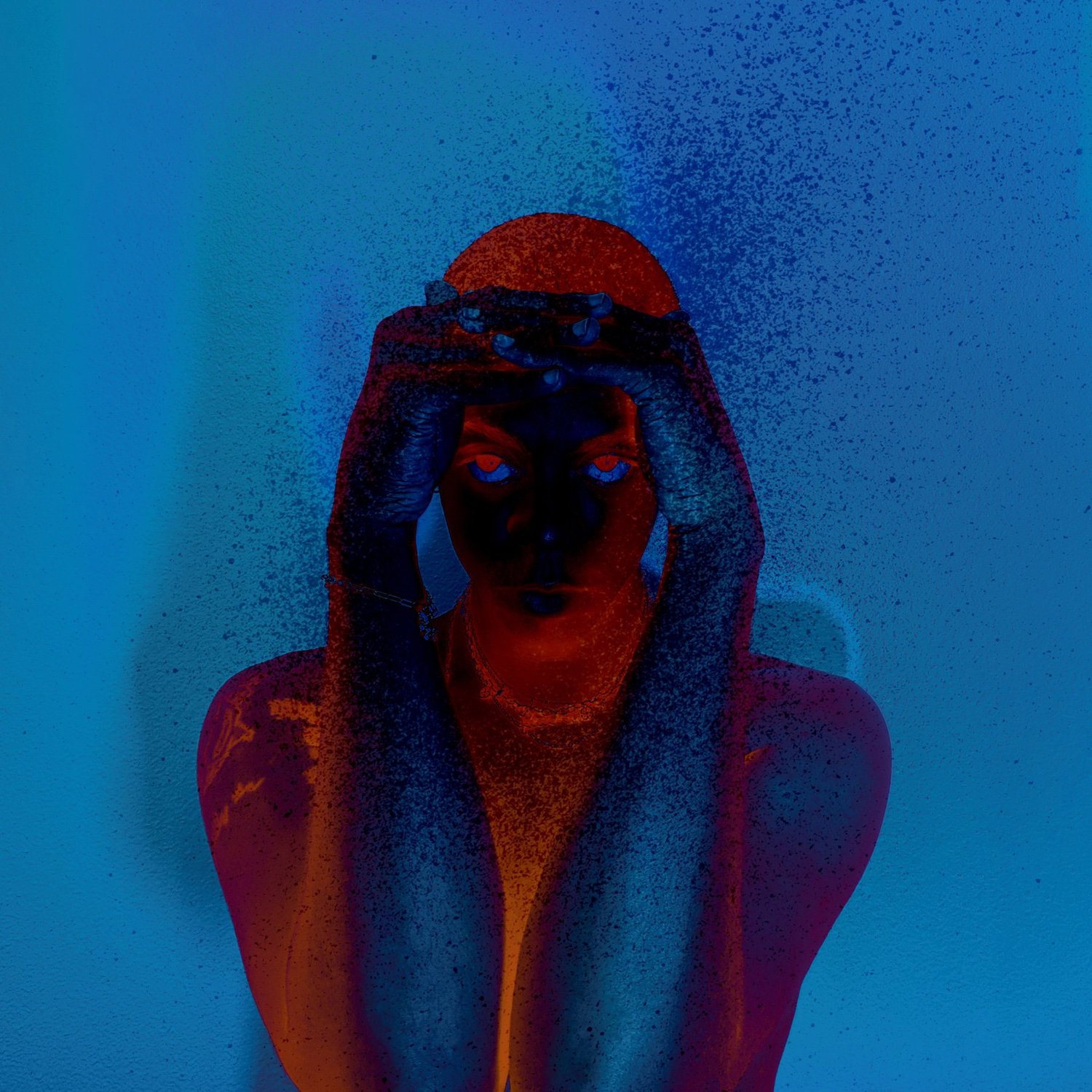 Parrka* in blue and red, with hands framing his face