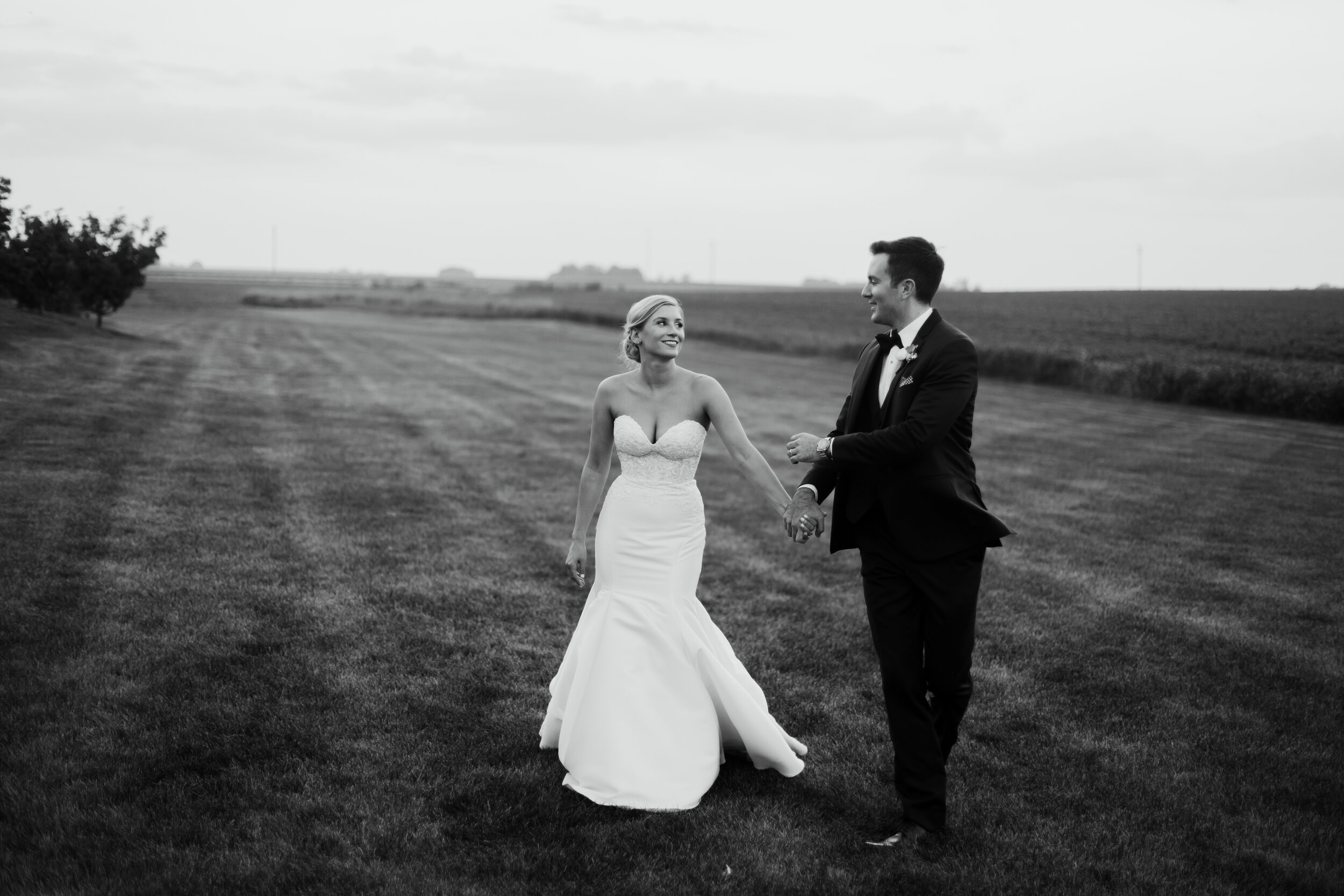 Bride and groom in field at sunset at Pear Tree Estate