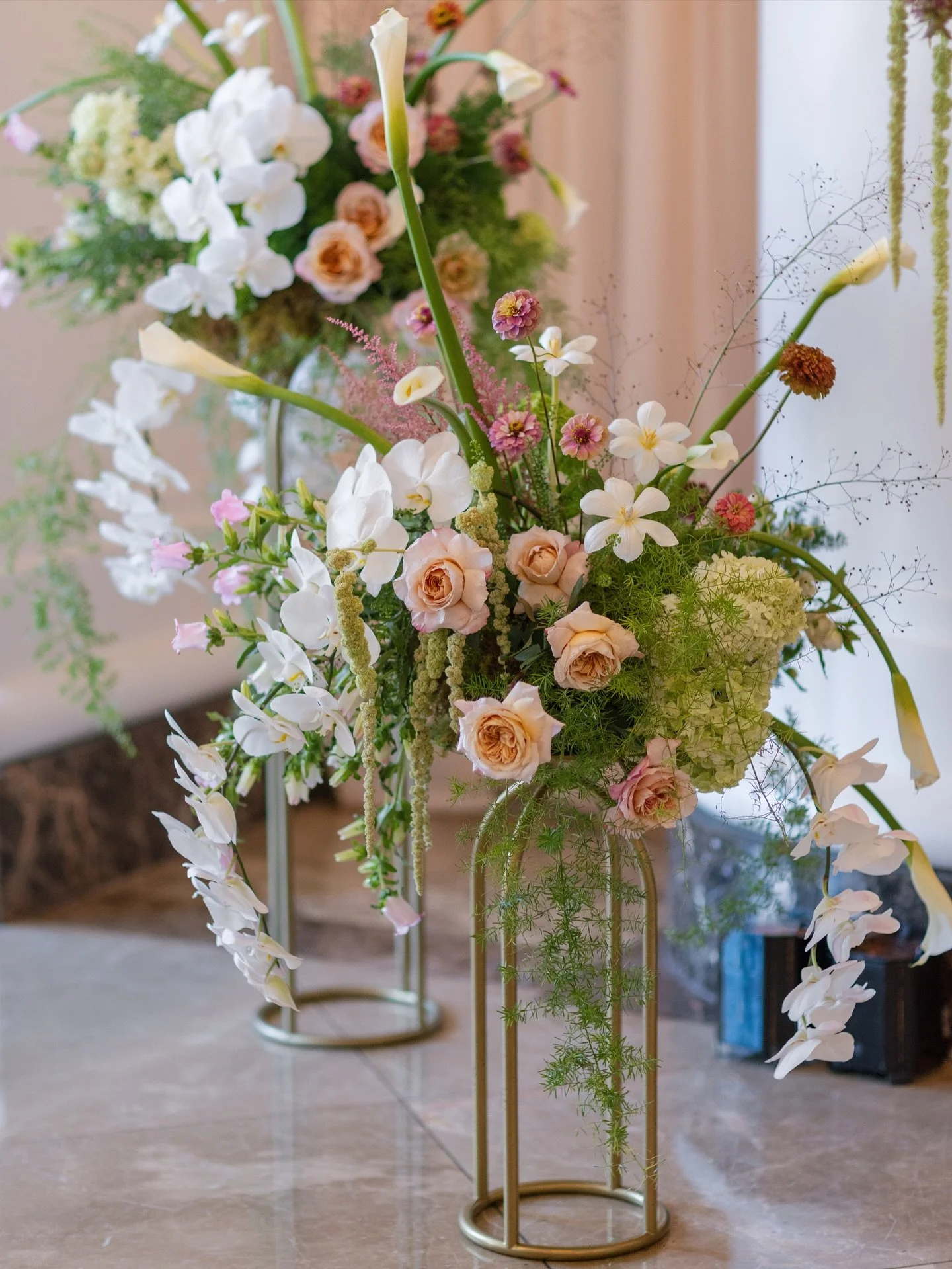 A glimpse into the pre-ceremony magic from Kristen &amp; Michael&rsquo;s wedding ✨
Before guests even arrived, the atmosphere was already set with dreamy florals overflowing with roses, orchids, calla lilies, and lush greenery. These golden stands he