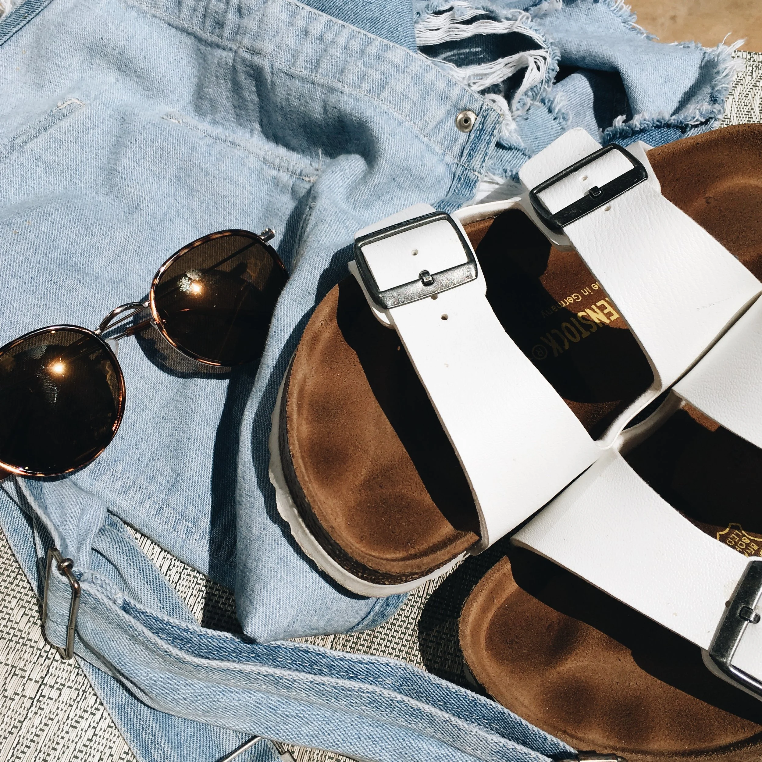 By Julia Baldwin Whether you're jetting off to the Caribbean, driving down to Miami, or just staying in your home town--there are a few items essential to any vacation. You'll definitely need a pair of cute and comfortable sandals, such as the white Birkenstock slip-on sandals pictured. You'll also want to have a pair of sunglasses that are both protective to your eyes and fashionable. Don't forget a beach coverup--such as t-shirt dress or overalls!