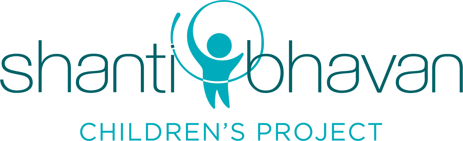 Logo for Shanti Bhavan Children's Project featuring a stylized blue human figure encircled by lines, with the organization's name and the words 'Children's Project' below.