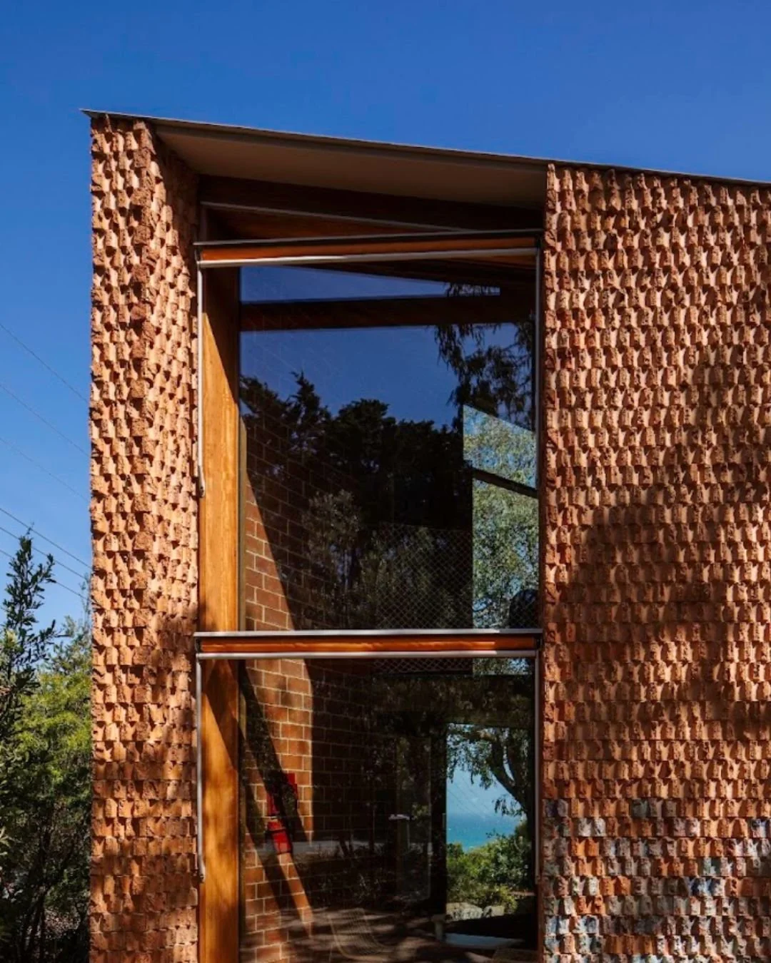 At John Wardle's Burnt Earth Beach House, every brick tells its own story. Hand-torn from an industrial extruder, each one is entirely one-of-a-kind.

Glazed and fired in a single step, the raw clay develops a striking palette of mottled greens and b