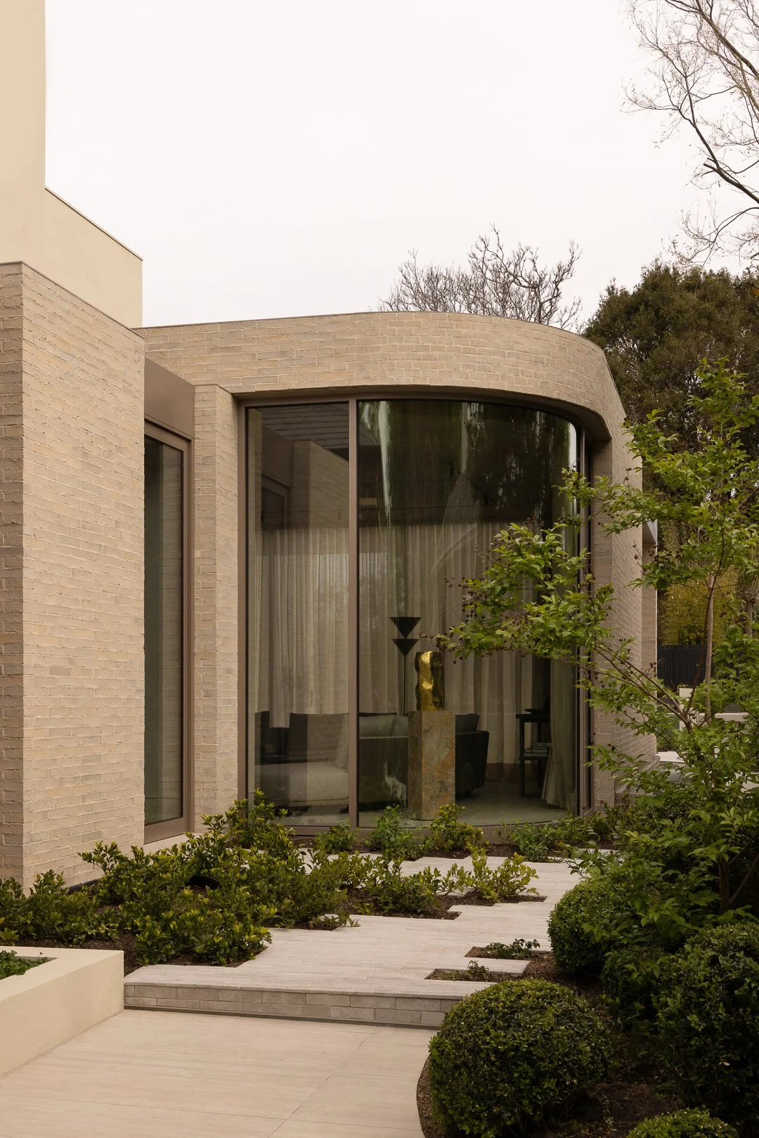This stunning renovation by @architecture.works demonstrates how brickwork can be both solid and fluid. Krause Empress Bricks in Ghost were selected for the curved forms of the facade, creating a seamless transition between the architecture and the g