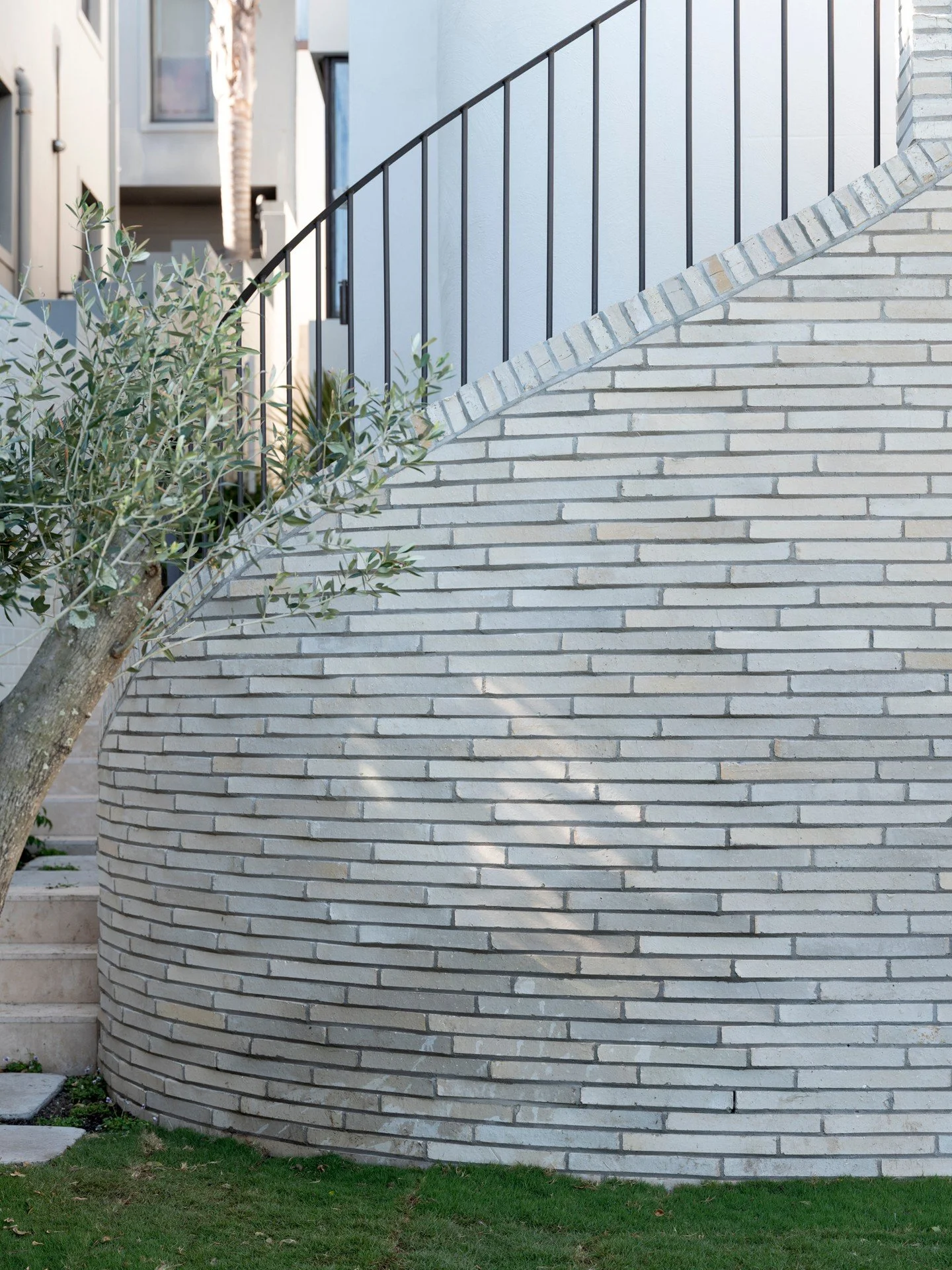 Executing a tight radius with a standard linear brick requires exceptional skill. At Bulkara Road, Bellevue Hill, this precision is on full display. The faceted rhythm of the brickwork defines the sweep of the wall, transforming a structural necessit