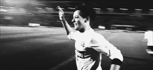 An animated gif of Louis, on the soccer field, coming running to high-five Harry.
