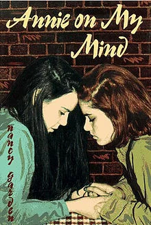 The cover of Annie On My Mind , by Nancy Garden: two teen girls clasp hands and press their foreheads together.