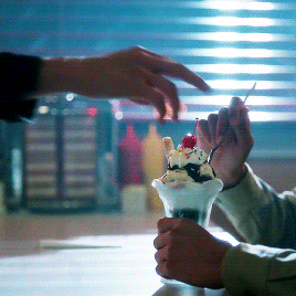 An animated gif in which Jughead Jones, on Riverdale , takes a maraschino cherry off the top of someone else’s sundae and insolently eats it.