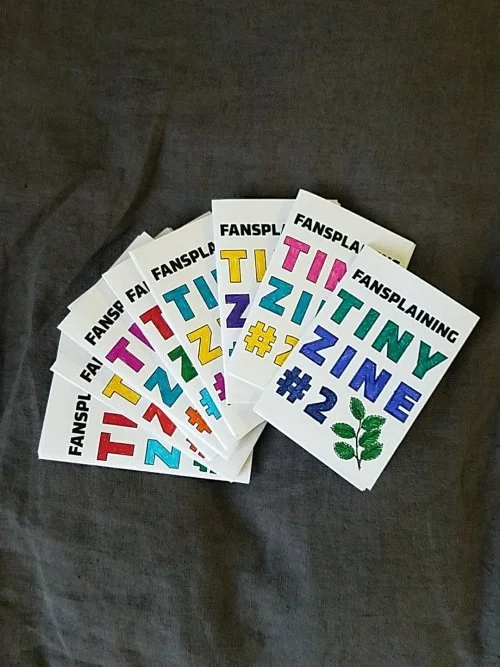 An array of rainbow-colored tiny zines.