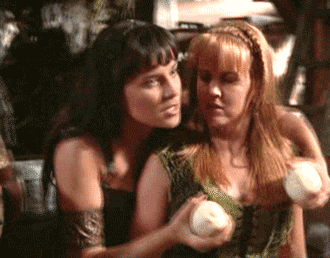 An animated gif of Xena coming up behind Gabrielle and holding a pair of onions in front of Gabrielle’s breasts, apparently saying something entertaining.