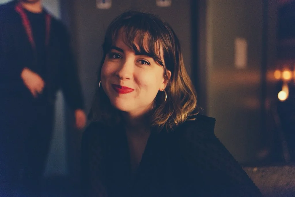 A headshot of Allyson Gross, wearing bright red lipstick.