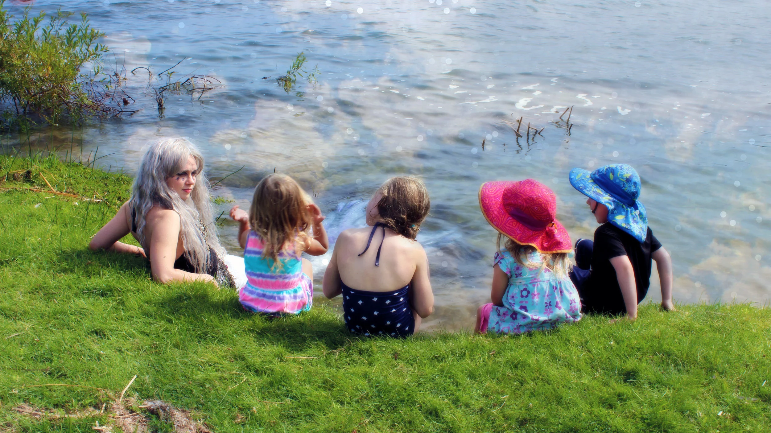Meeting a real mermaid... Mermaid Phantom can swim up from out of the lake to meet and greet children and special guests in the warm-weather seasons. Here, she sits with a group of four children as they ask questions about life as a mermaid.