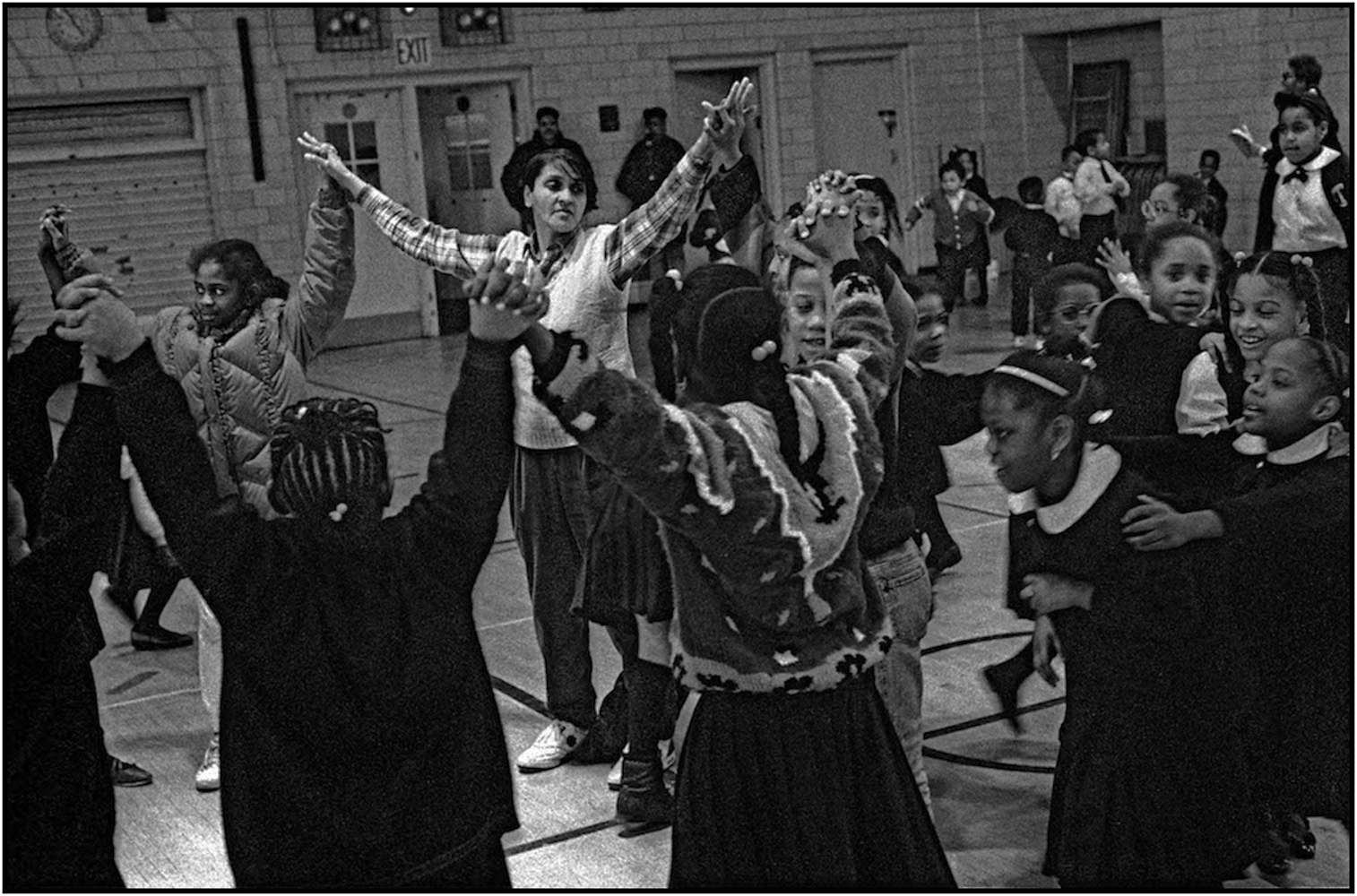   School Aide Gloria Jackson leads children at circle game in an after-school program at P.S. 176, Queens. 1991.  
