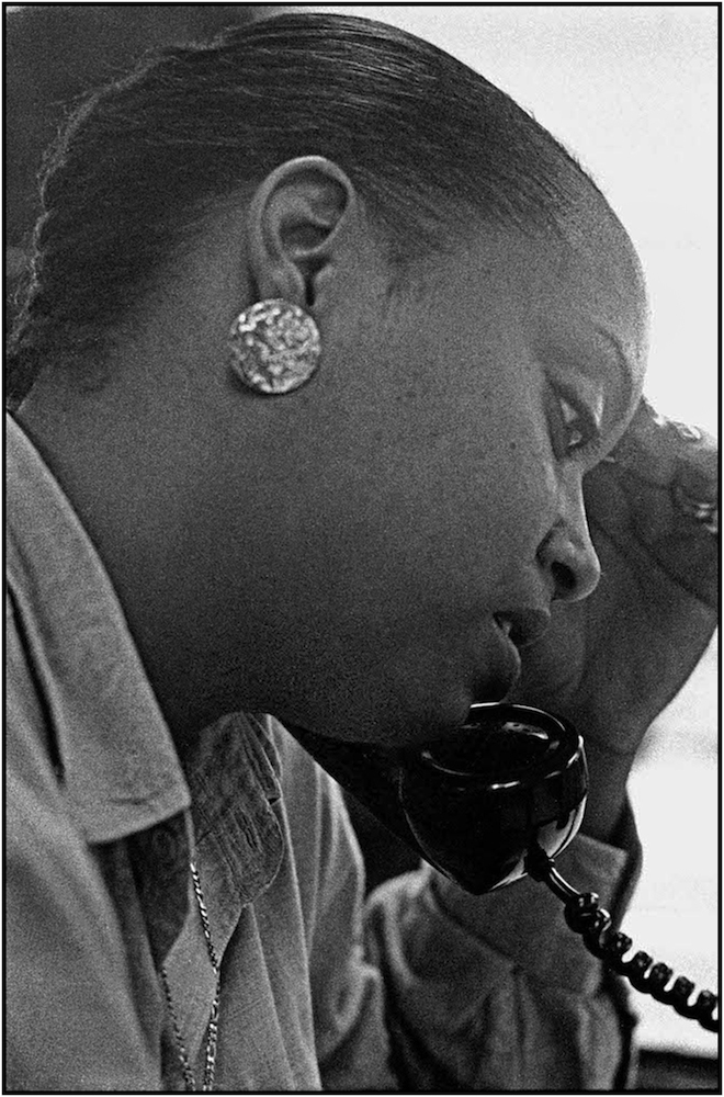 An eligibility specialist at the Bergen-Willis Income Maintenance Center in The Bronx, gives a welfare client telephone assistance. 1988.