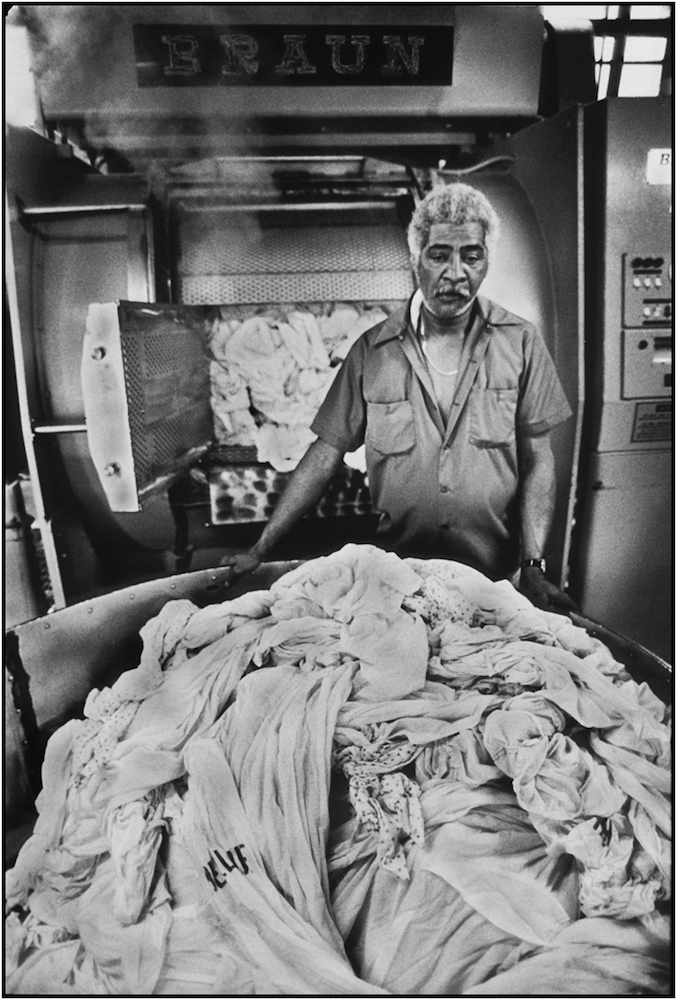 Laundry worker Jose Pedroso handles his share of six tons of daily wash at Bellevue Hospital, Manhattan. 1985.