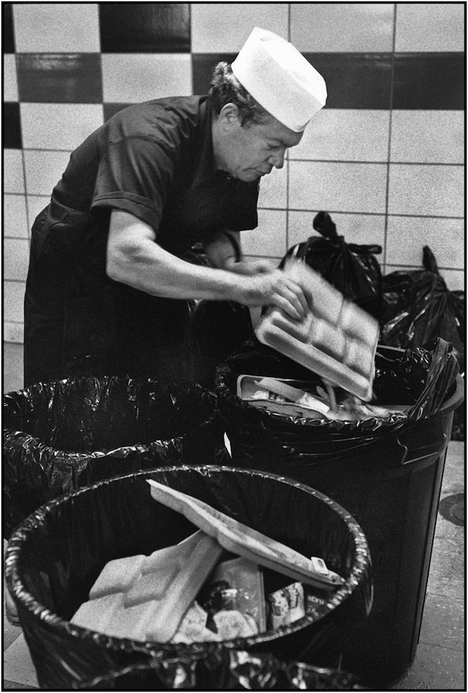 Board of Education, Office of School Nutrition Services workers Emanuel Palumbo collecting garbage in cafeteria, Manhattan. 1991.