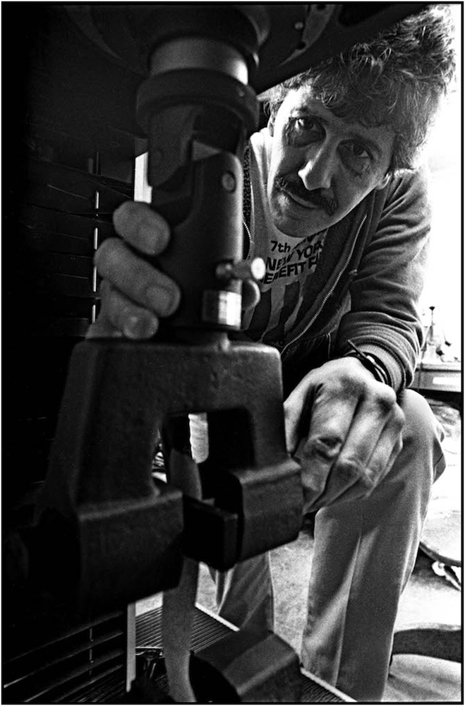 Walter Fischer, Assistant Chemist at the Department of General Services, tests strength of paper towel for use in schools, Manhattan. 1986.